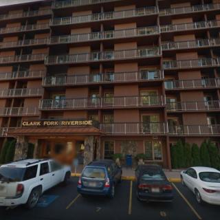 A multi-story apartment building with a parking lot in the foreground.