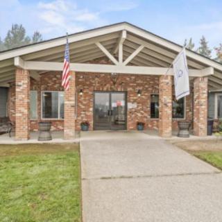 A brick building with a flag at the entrance and a paved walkway.