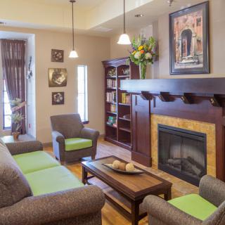 A cozy living room featuring comfortable seating, a fireplace, and a well-stocked bookshelf, perfect for relaxation and reading.