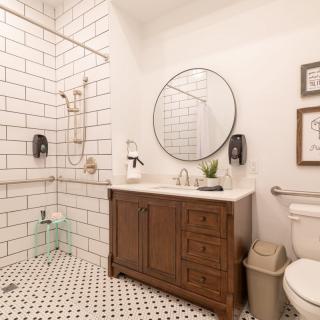 Modern minimalist bathroom with a tiled shower and wooden vanity.