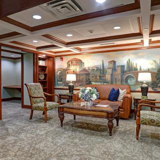 A traditionally styled lobby with comfortable seating and a decorative mural.