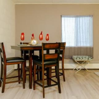 A cozy dining area featuring a wooden table with seating and decorative elements.