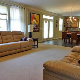 A spacious living room with an open concept design, featuring comfortable sofas and a dining area.