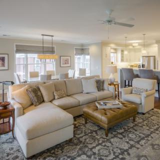 A spacious living room with an open concept design featuring a comfortable sofa, coffee table, and dining area.