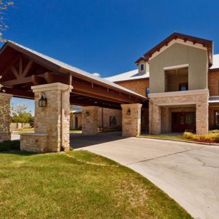 A modern residential building with a covered entrance and well-maintained landscaping.