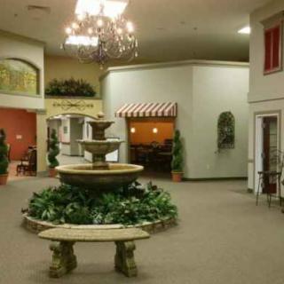 A spacious interior with a decorative fountain and elegant chandelier.