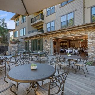 An outdoor patio area with tables and chairs in front of a building, providing a pleasant dining setting.