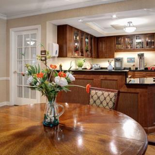 A cozy dining area with a wooden table and a view into a modern kitchen.