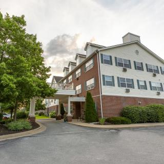 Exterior view of a hotel with trees and landscaping.