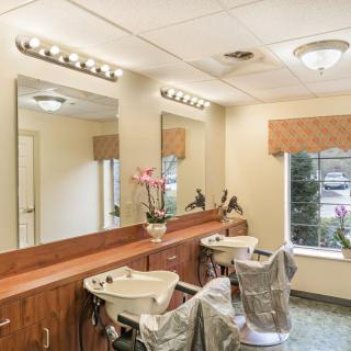 A well-lit hair salon interior with chairs and sinks.