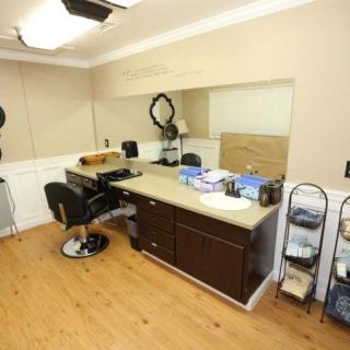 Interior of a modern barber shop with styling station and mirror.