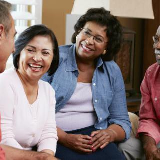A group of people sitting together, engaged in a cheerful conversation.