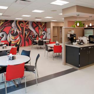 A modern cafe interior featuring colorful artwork and contemporary furniture.
