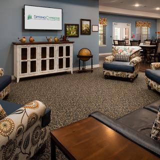 A cozy living room with comfortable seating and a TV, featuring stylish interior design.