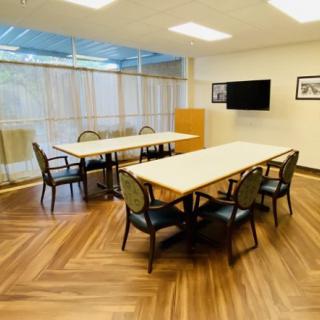 A well-lit conference room with tables and chairs arranged for a meeting.