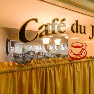 The interior of Caf du Jardin, showcasing its cozy ambiance and decorative sign.
