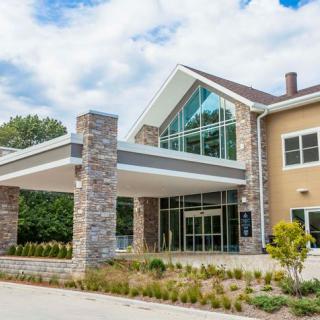 A modern building entrance with large glass windows and stone accents.