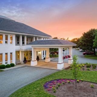 A beautiful building entrance with a landscaped garden at sunset.