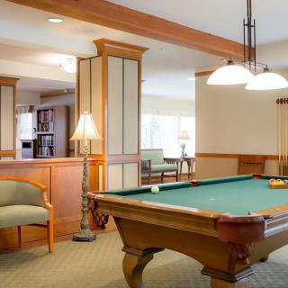 A cozy recreation room featuring a billiards table and comfortable seating.