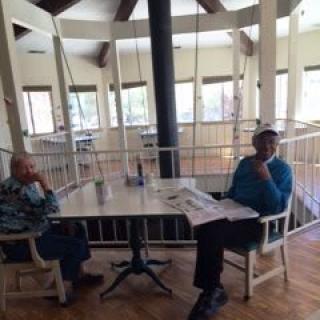 Two individuals seated at a table in a well-lit indoor space.