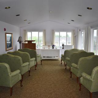 Interior view of a ceremonial room with arranged seating and natural lighting.