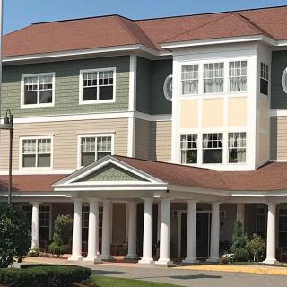A multi-story residential building with a columned entrance.