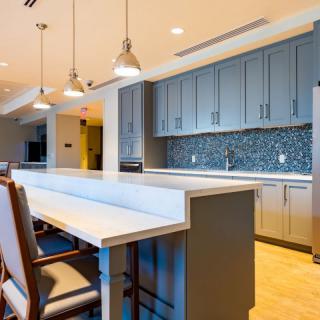 A modern kitchen with an island and pendant lighting.