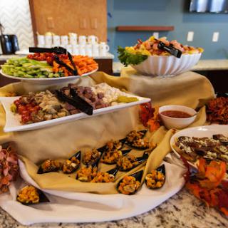 A beautifully arranged buffet featuring a variety of appetizers, salads, and sauces, perfect for any gathering.