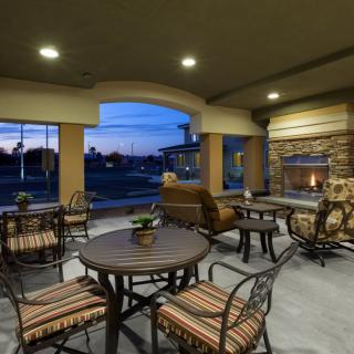A cozy outdoor patio with a fireplace and comfortable seating at dusk.