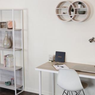 A minimalist home office setup with a modern desk and shelving.