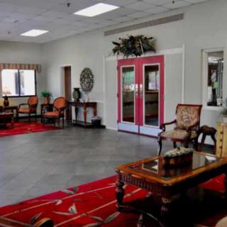 A spacious lobby featuring elegant furniture and red accents.