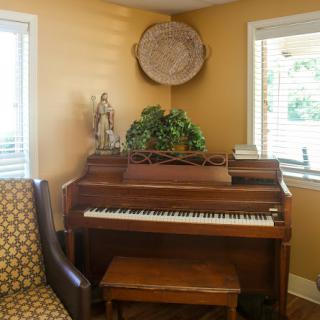 A cozy corner featuring a piano and comfortable seating, adorned with decorative elements.
