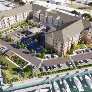 Aerial view of a residential complex with a marina and parking facilities.