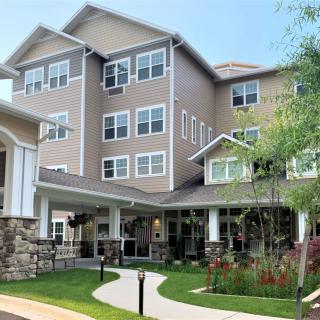 A modern multi-story residential building with well-maintained landscaping.