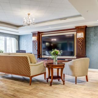 A luxurious living room with elegant furnishings and a large television.
