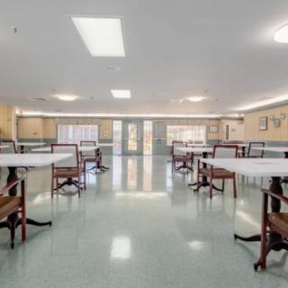 An empty dining room with several tables and chairs arranged neatly.