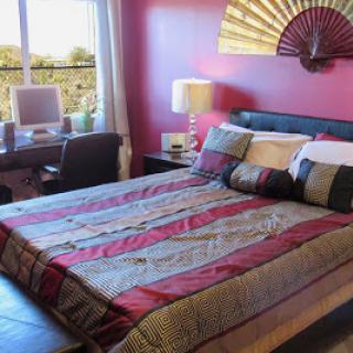 A cozy bedroom featuring a colorful bedspread and modern decor.