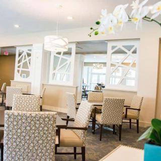 A modern and elegantly designed seating area with patterned chairs and tables under a stylish light fixture.