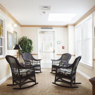 A cozy indoor seating area with four rocking chairs and natural lighting.