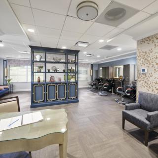 A modern interior space featuring a lobby with seating, a reception desk, and exercise equipment.