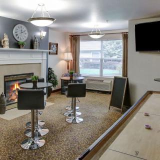 A cozy living room with modern seating, a fireplace, and a wall-mounted TV.