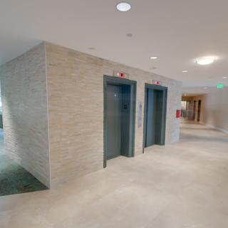 A modern hallway featuring two elevator doors.