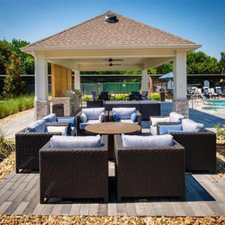 Outdoor patio seating area next to a pool with a gazebo.