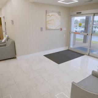 A spacious and modern lobby with a clean design, featuring comfortable seating and an entrance.