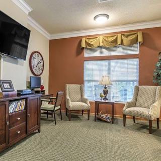 A cozy living room with elegant furniture and a wall-mounted TV.