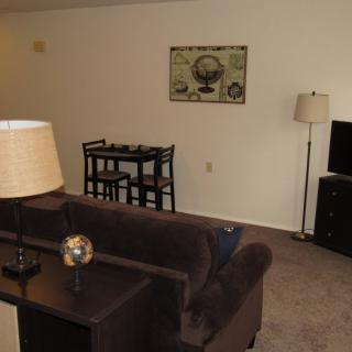 A cozy living room with a sofa, dining table, and television.