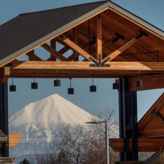 A snow-capped mountain framed by a wooden architectural structure.