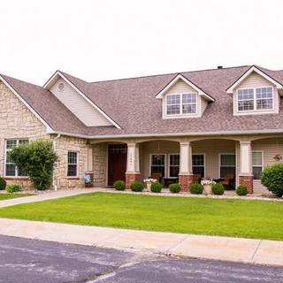 A suburban house with a neatly maintained lawn and a brick exterior.