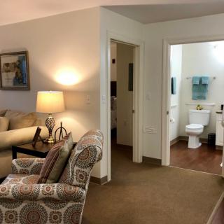 A cozy living room with a view into a bathroom through an open door.