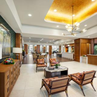 A modern lobby interior featuring stylish furniture, elegant chandeliers, and a welcoming reception area.